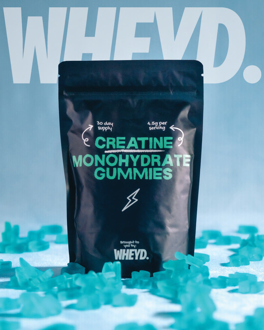 Pouch of WHEYD Creatine Monohydrate Gummies surrounded by blue gummies